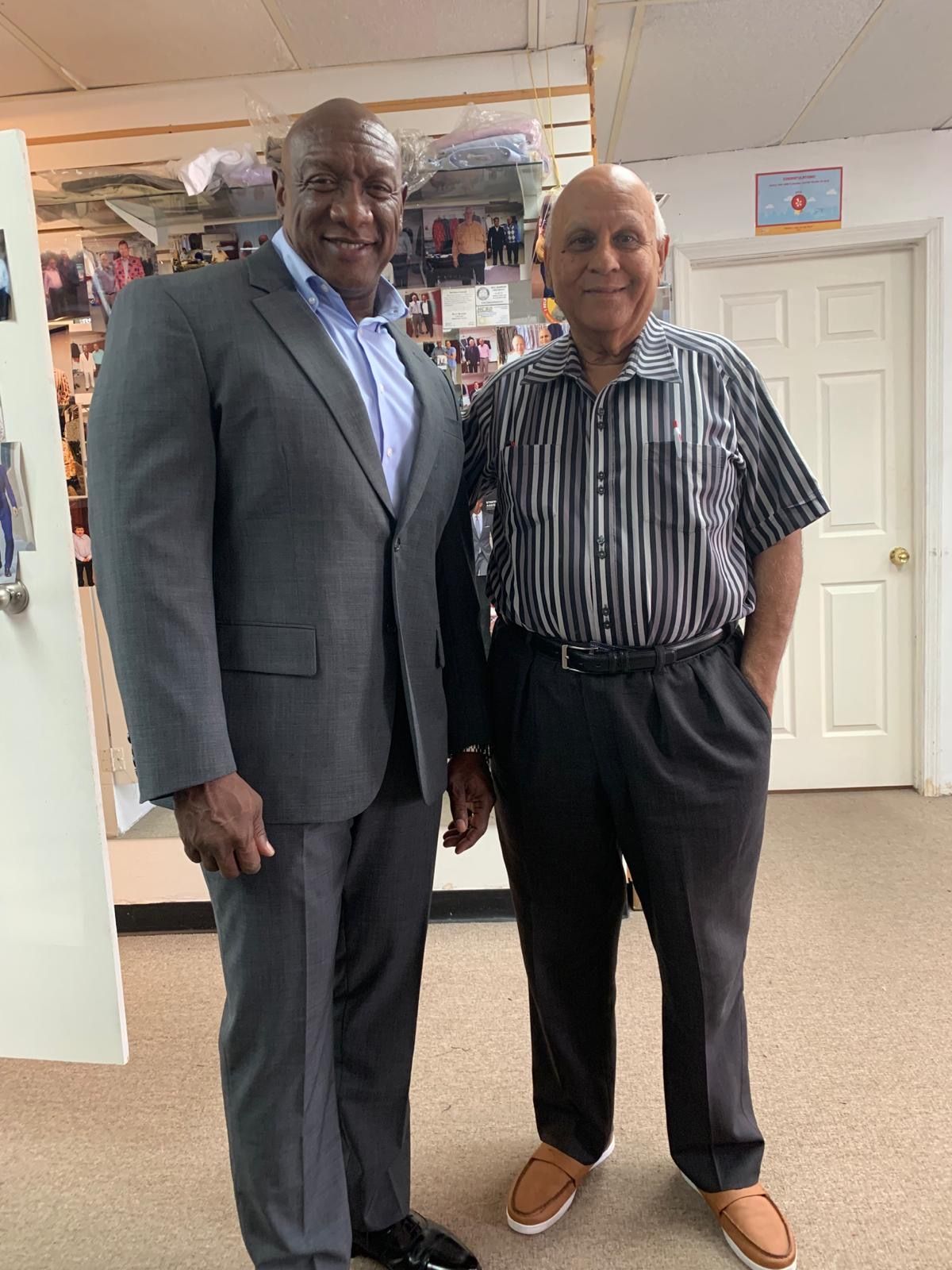 two men in suits are standing next to each other in a room