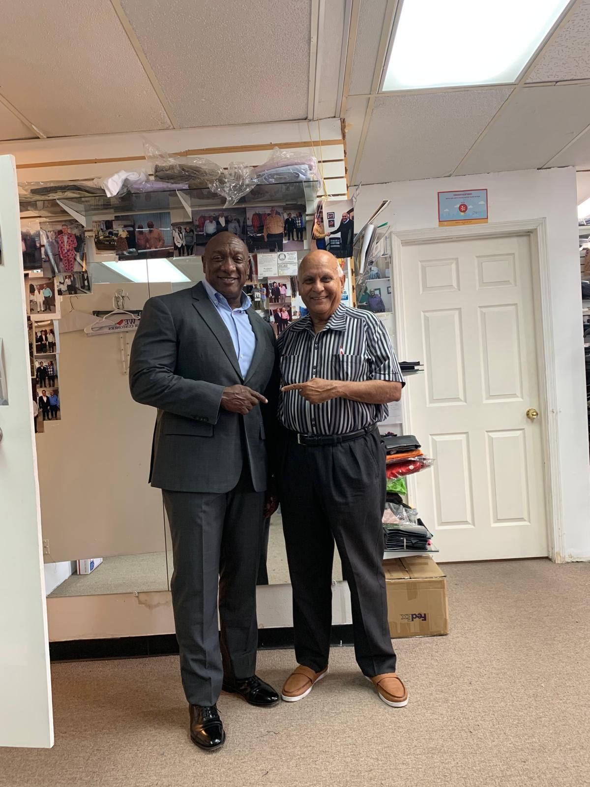 two men in suits are standing next to each other in a room