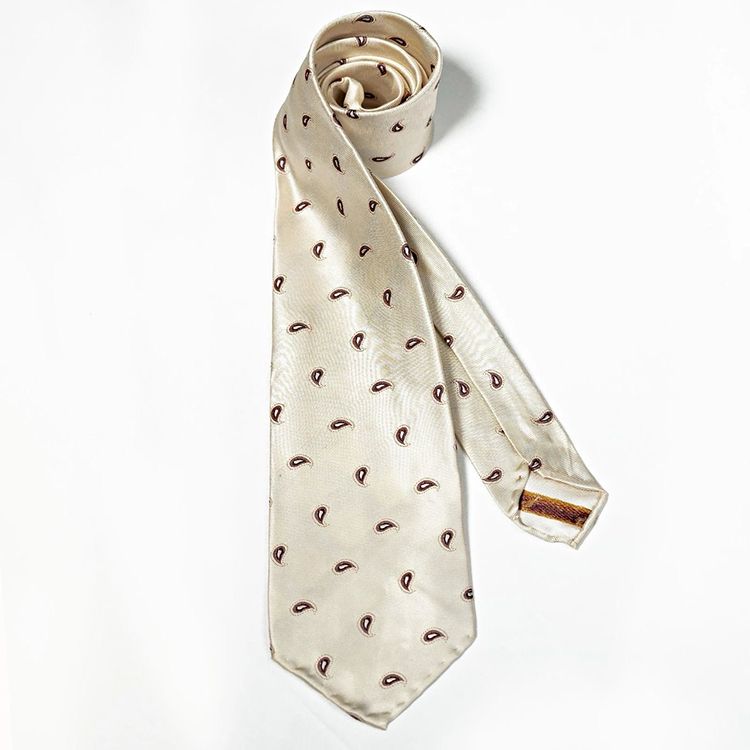 A white tie with brown polka dots on it