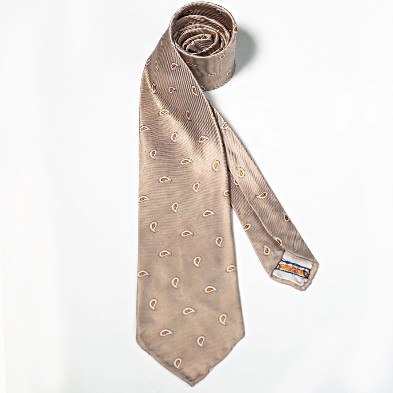 A tan tie with a pattern of horseshoes on it