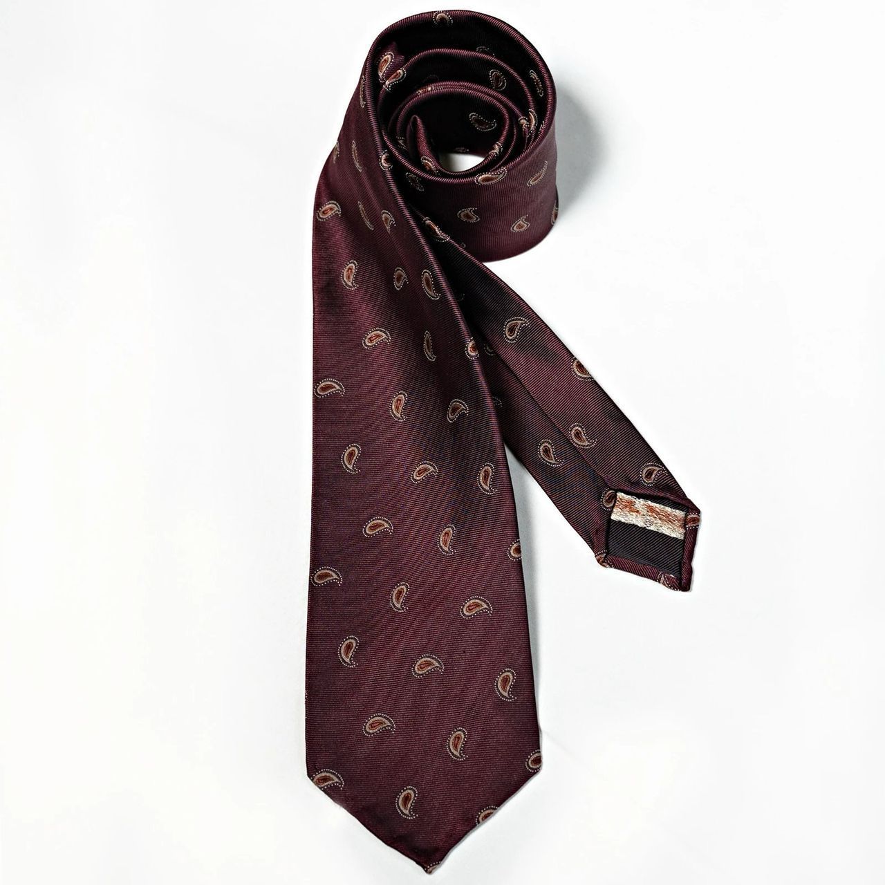 A burgundy tie with a paisley pattern on it