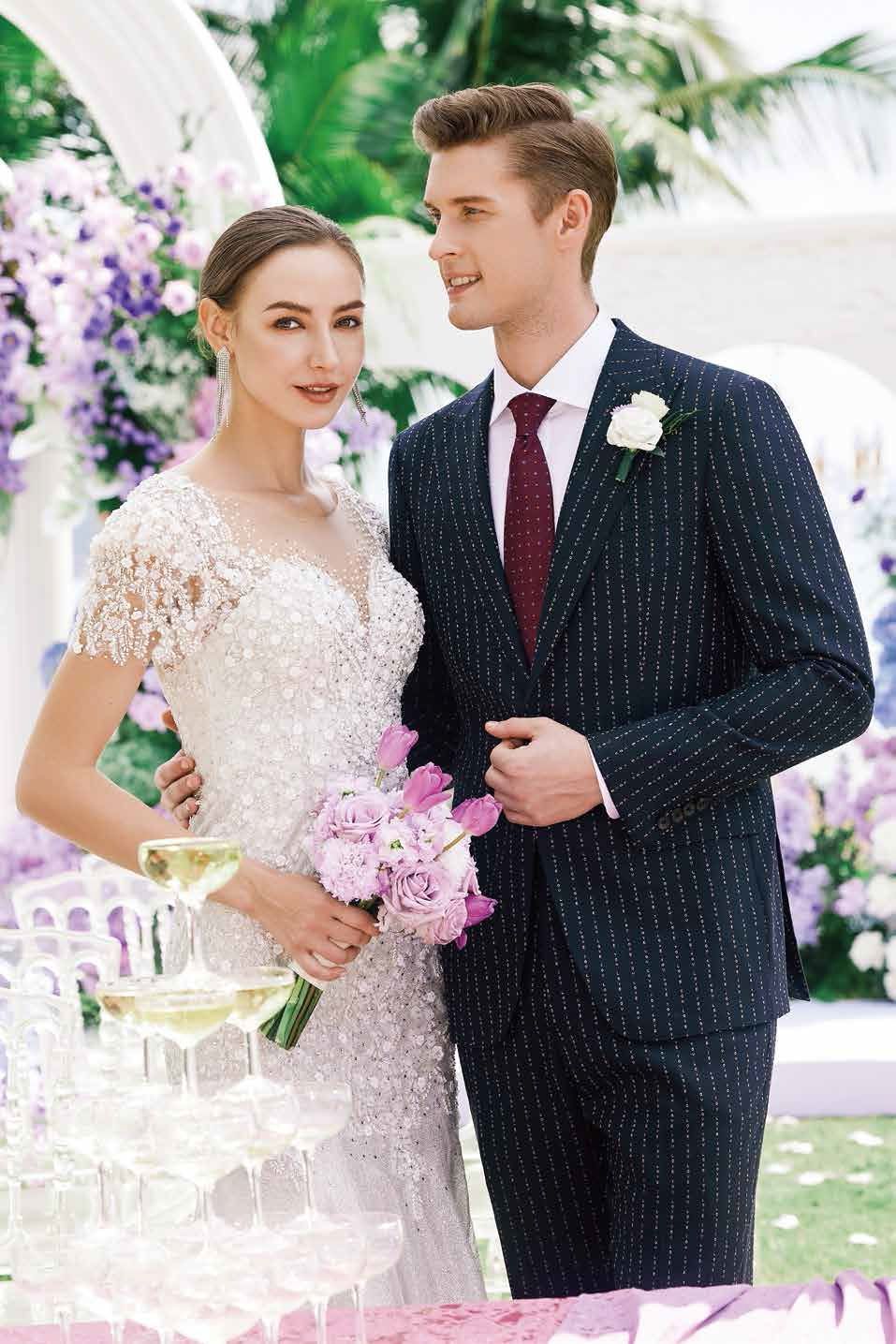 A bride and groom are posing for a picture at their wedding.