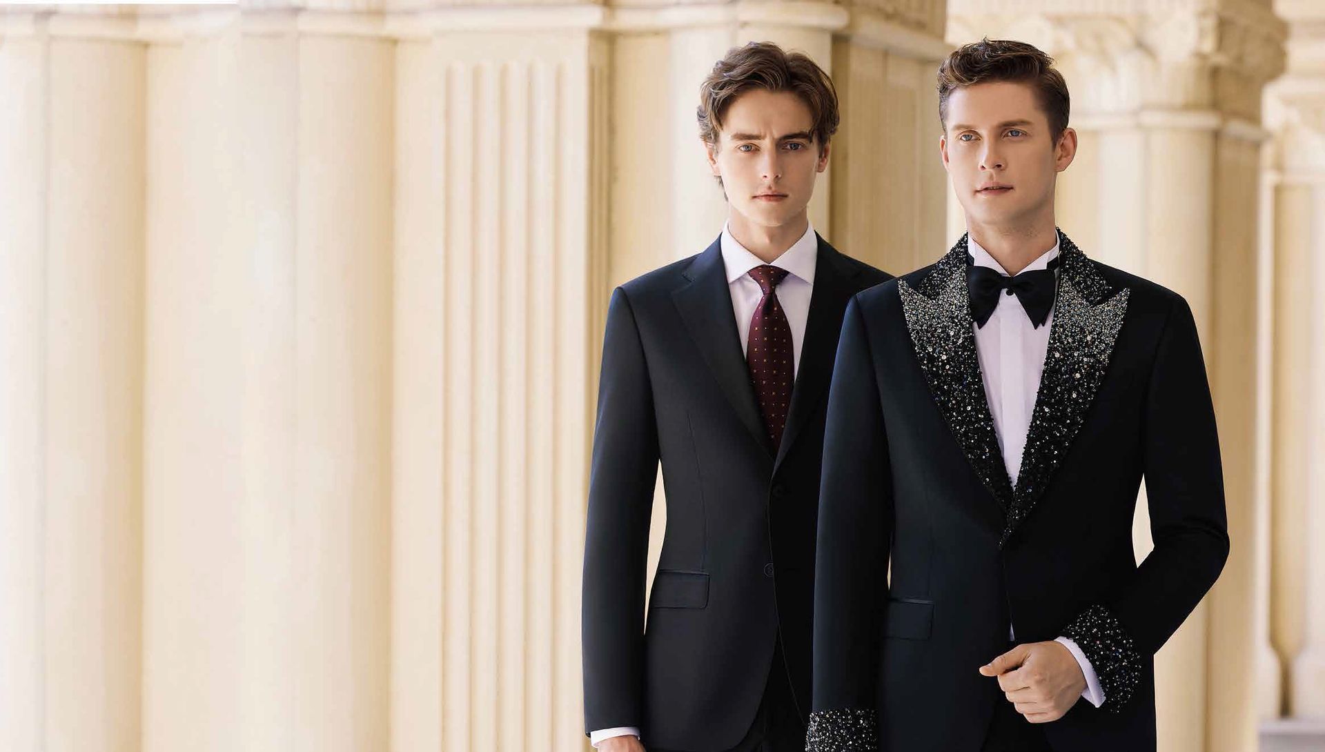 Two men in suits and ties are standing next to each other.