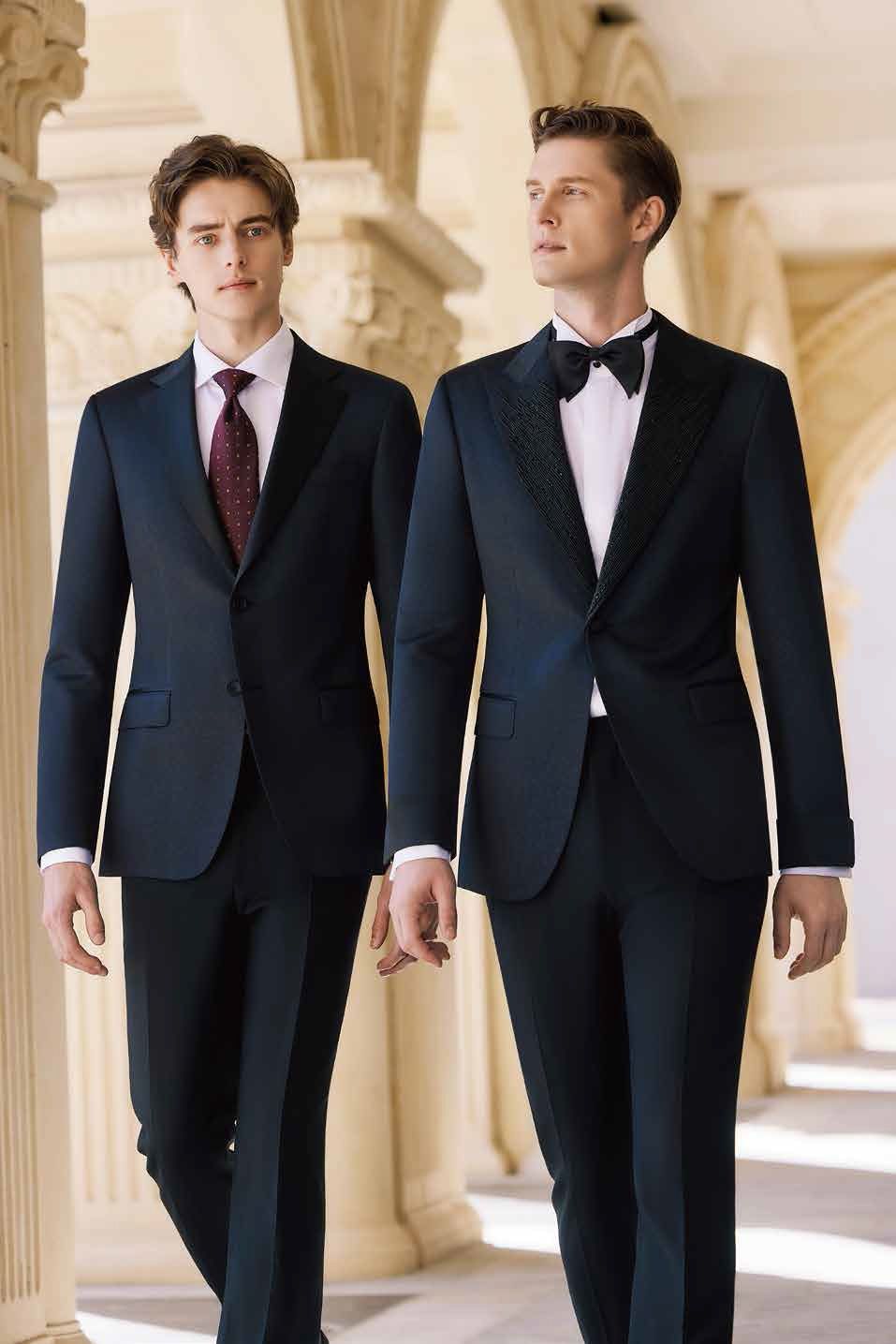 Two men in suits and ties are walking down a hallway holding hands.