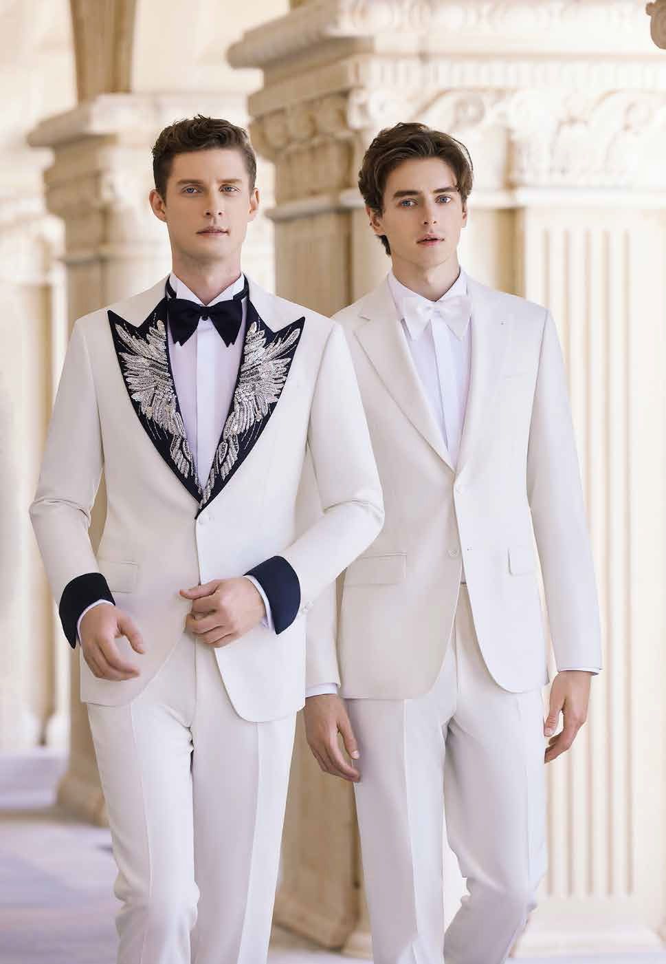 Two men in white suits and bow ties are standing next to each other.