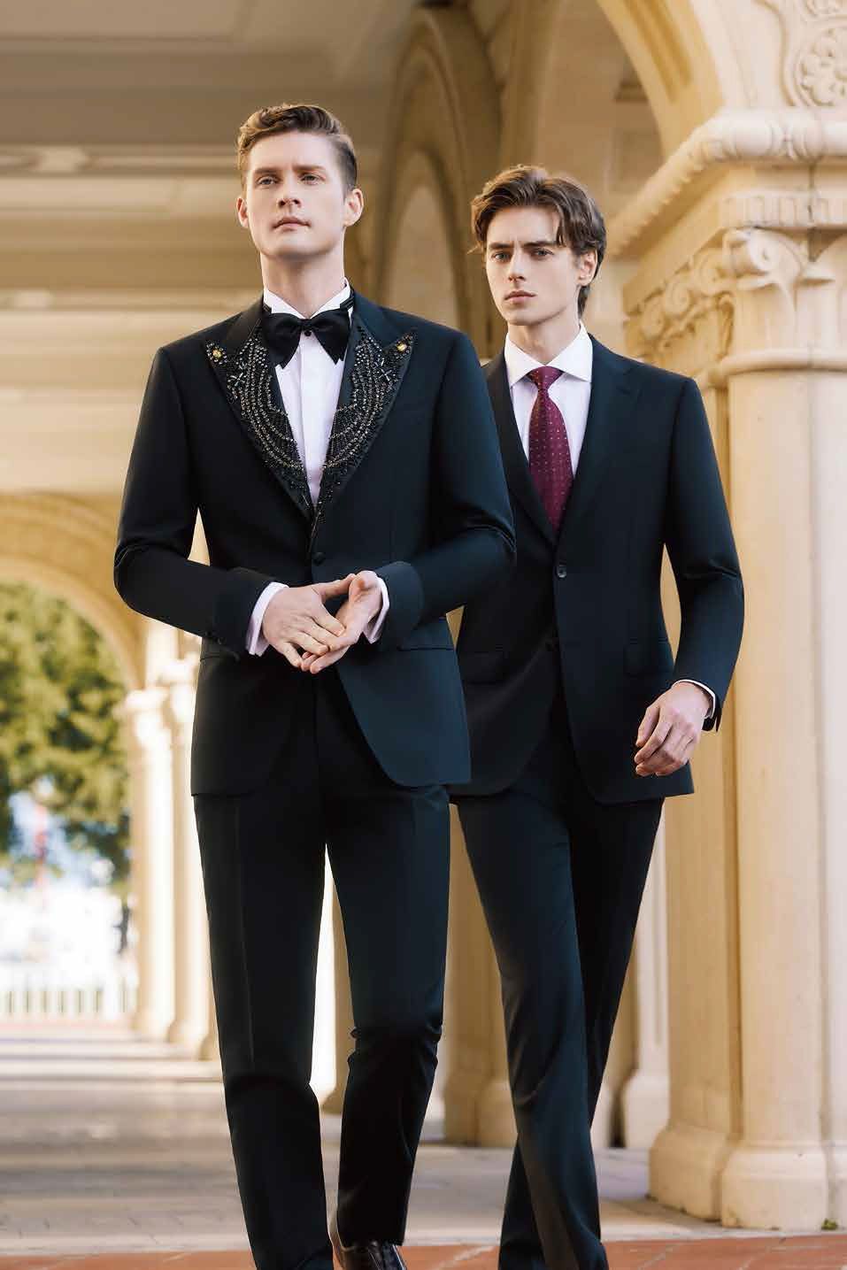 Two men in suits and ties are walking down a sidewalk.