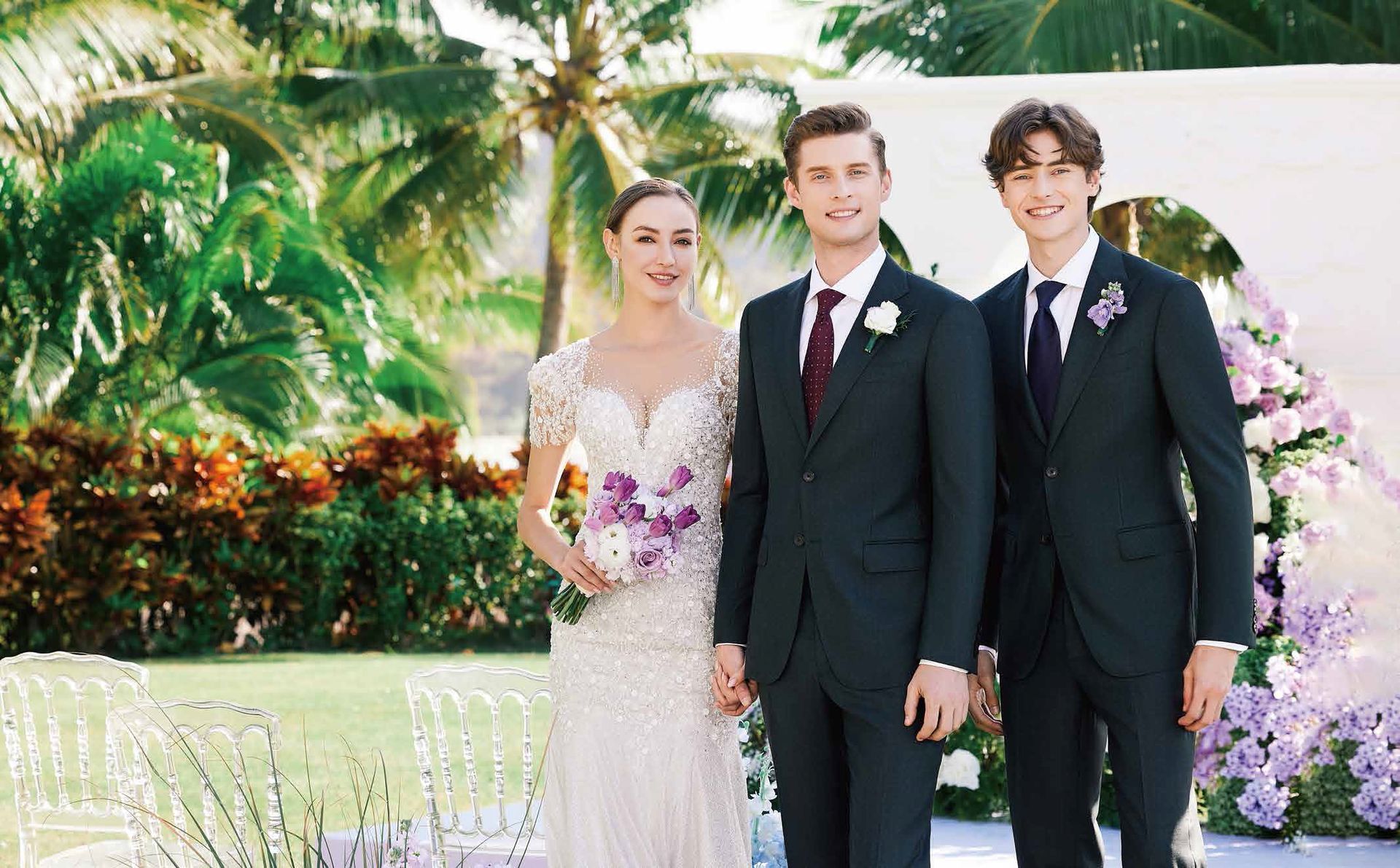 A bride and groom are posing for a picture with two men in suits.