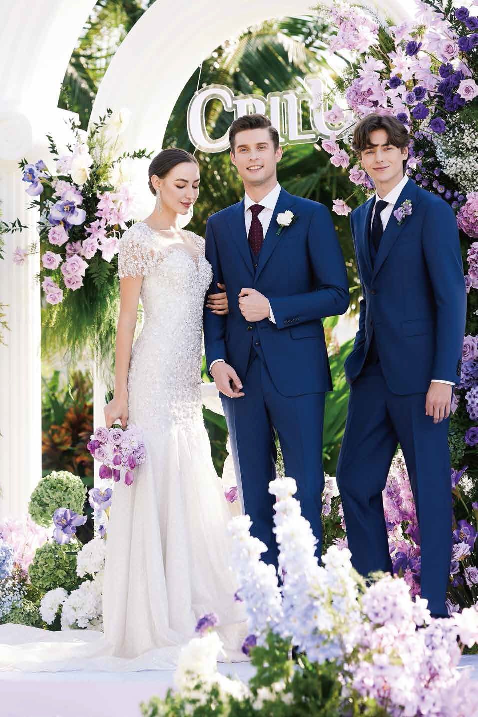 A bride and groom are posing for a picture with two men in suits.