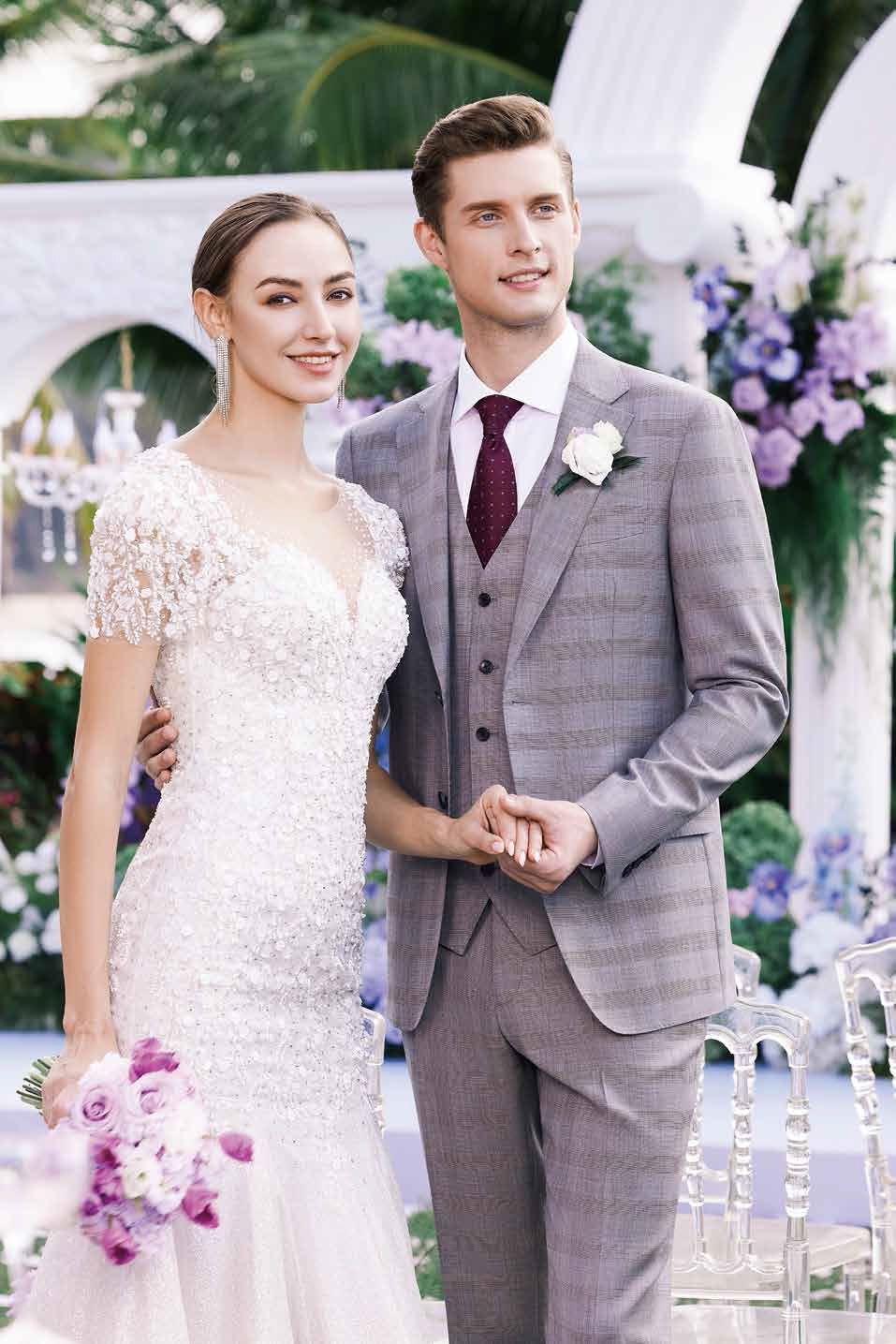 A bride and groom are posing for a picture at their wedding.