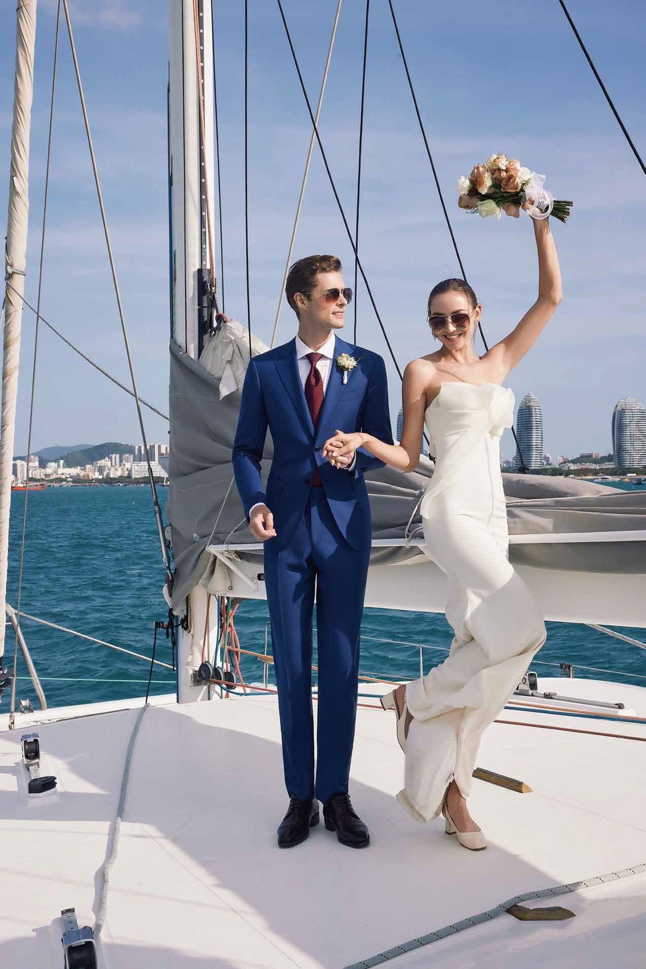 A bride and groom are posing for a picture on a sailboat.