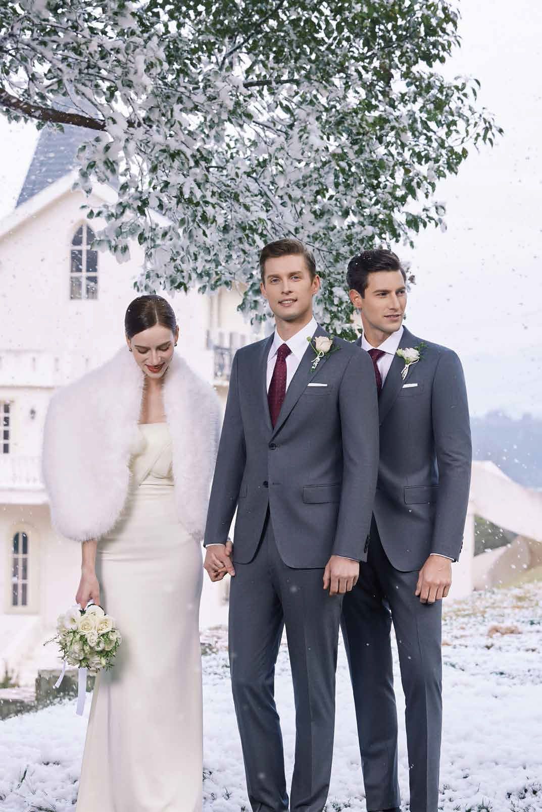 A bride and her two groomsmen are standing in the snow holding hands.