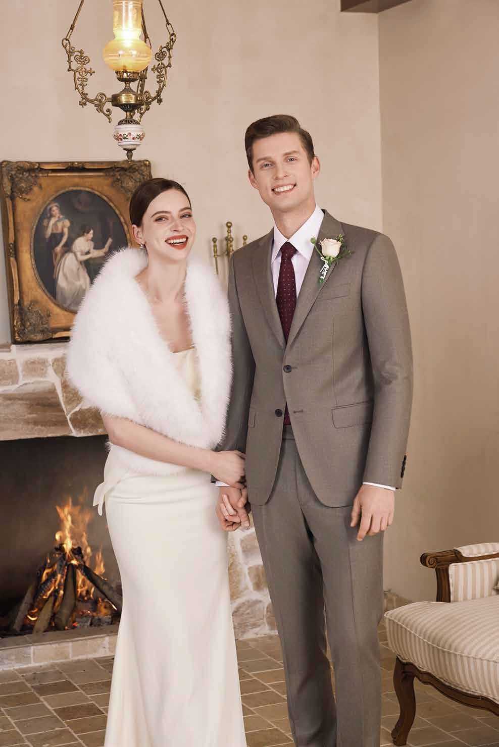 A bride and groom are posing for a picture in front of a fireplace.