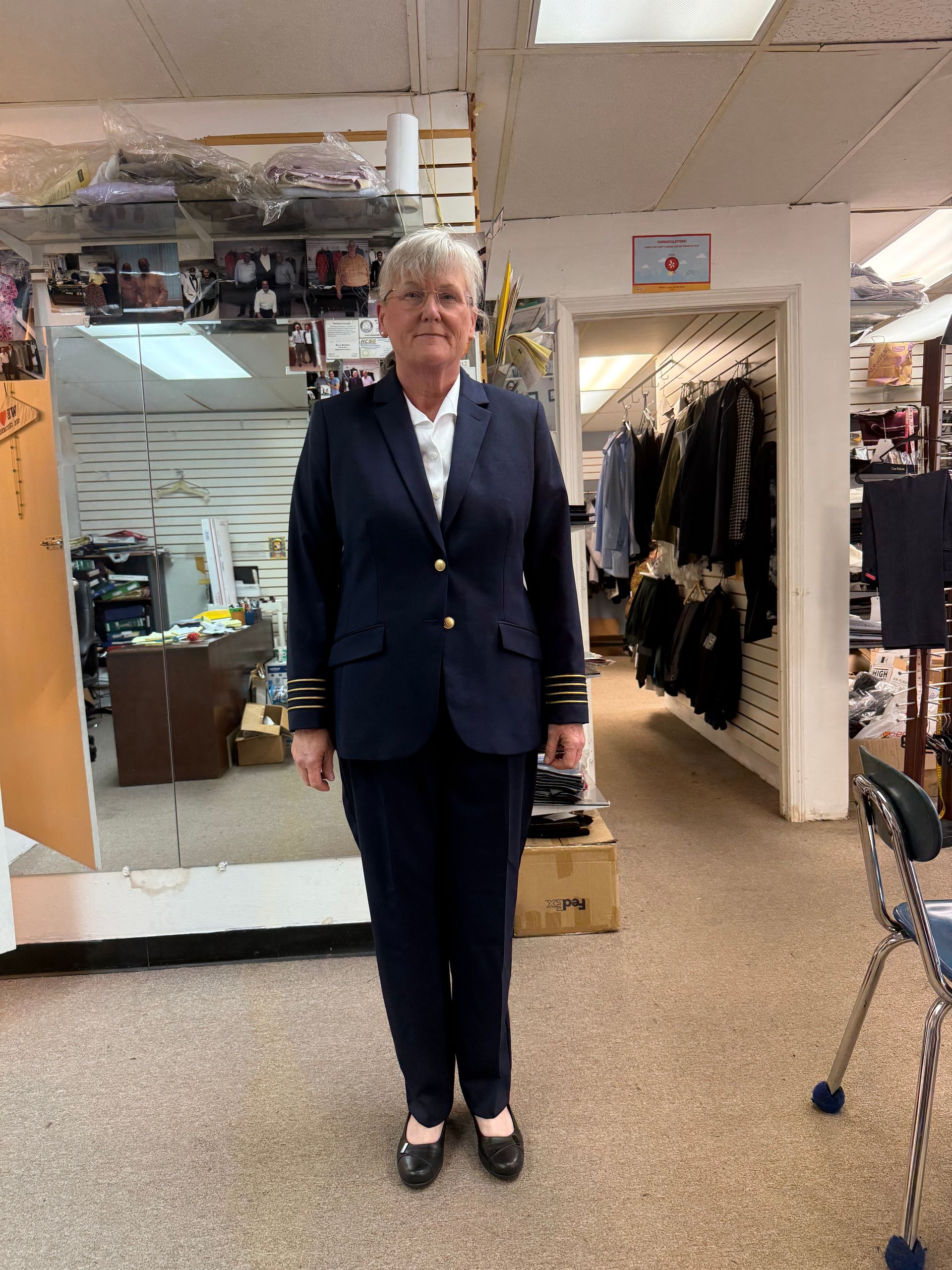 A woman in a suit is standing in a store.