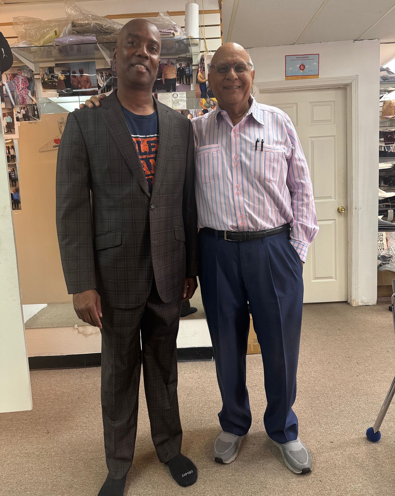 Two men in suits are standing next to each other in a room.