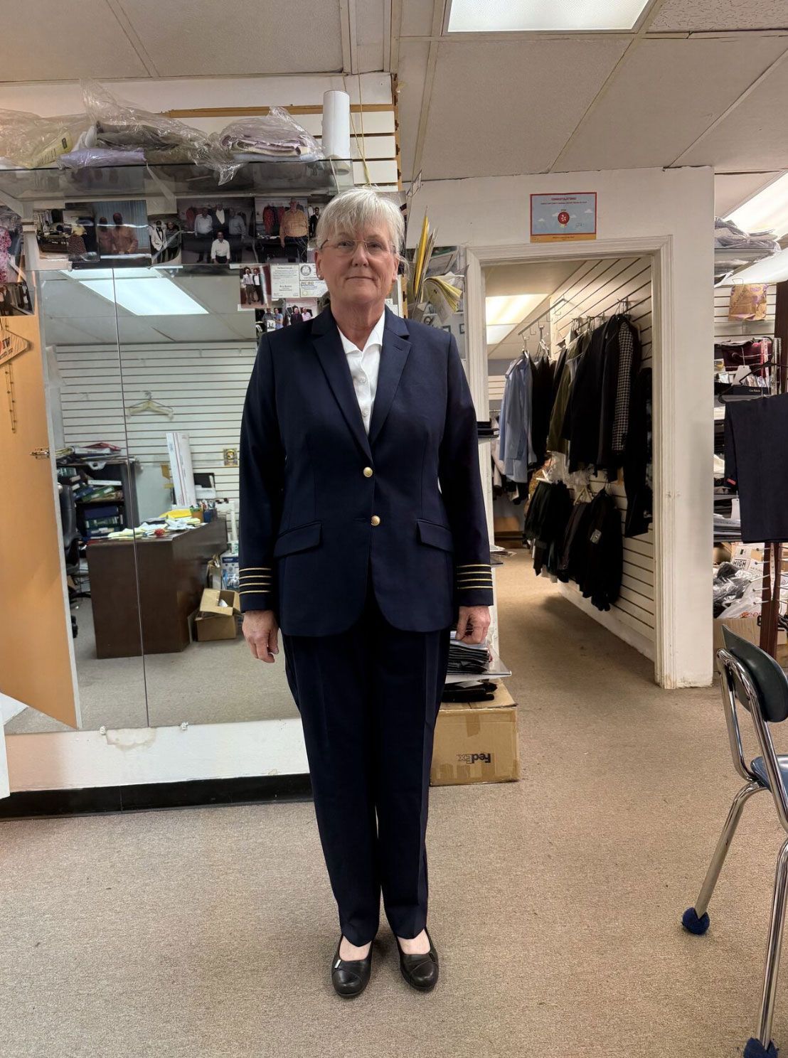 A woman in a suit is standing in a store.