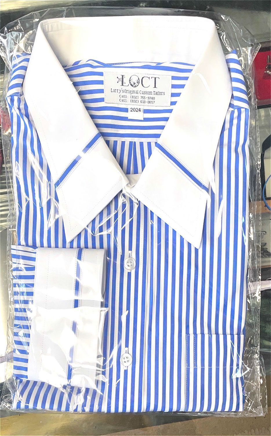 A blue and white striped dress shirt is wrapped in plastic