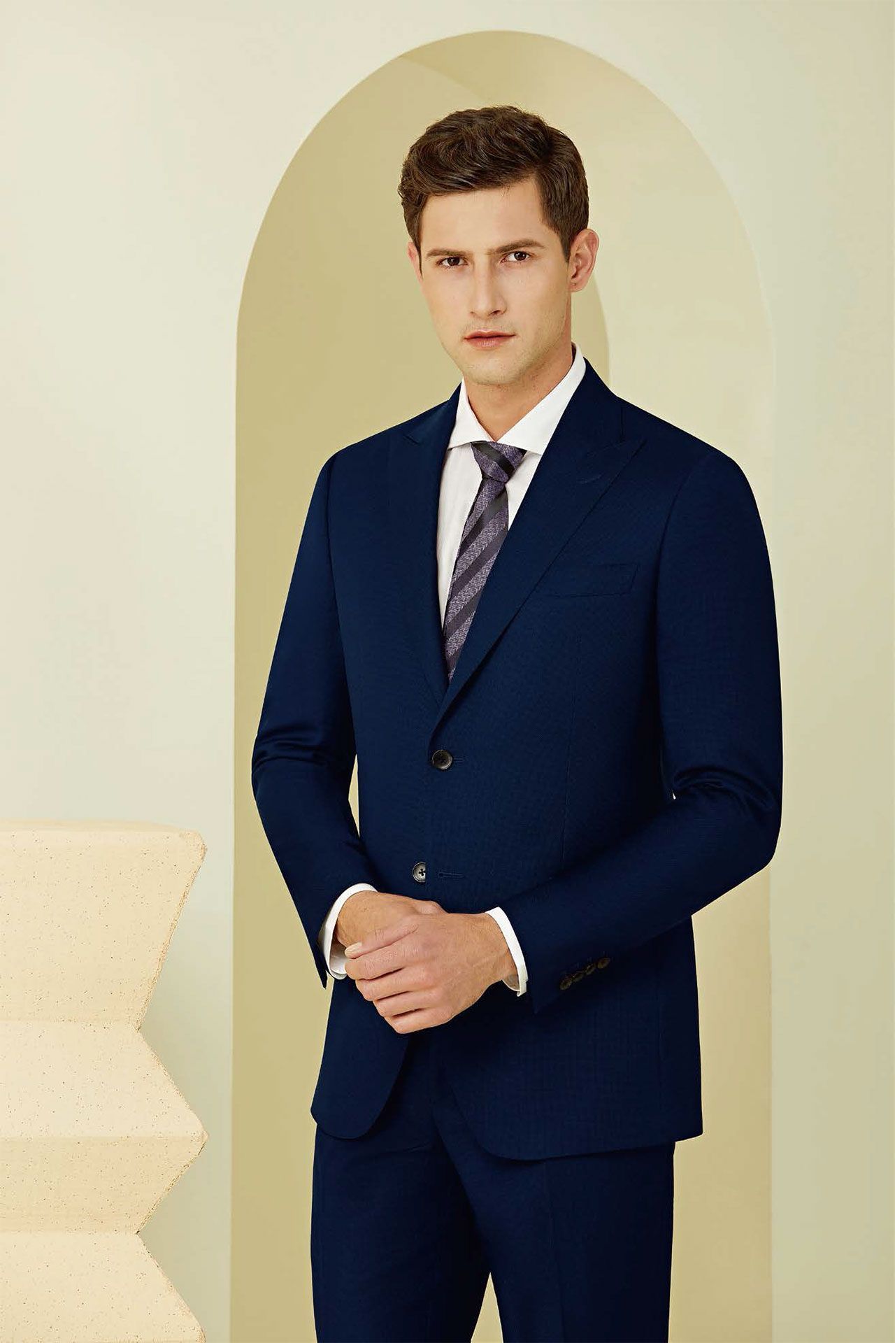 A man is wearing a blue suit and tie