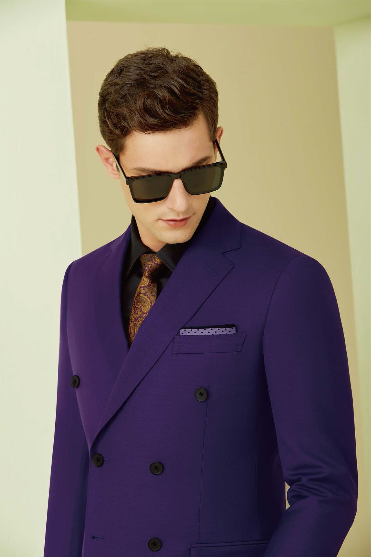 A man is wearing a purple suit and sunglasses