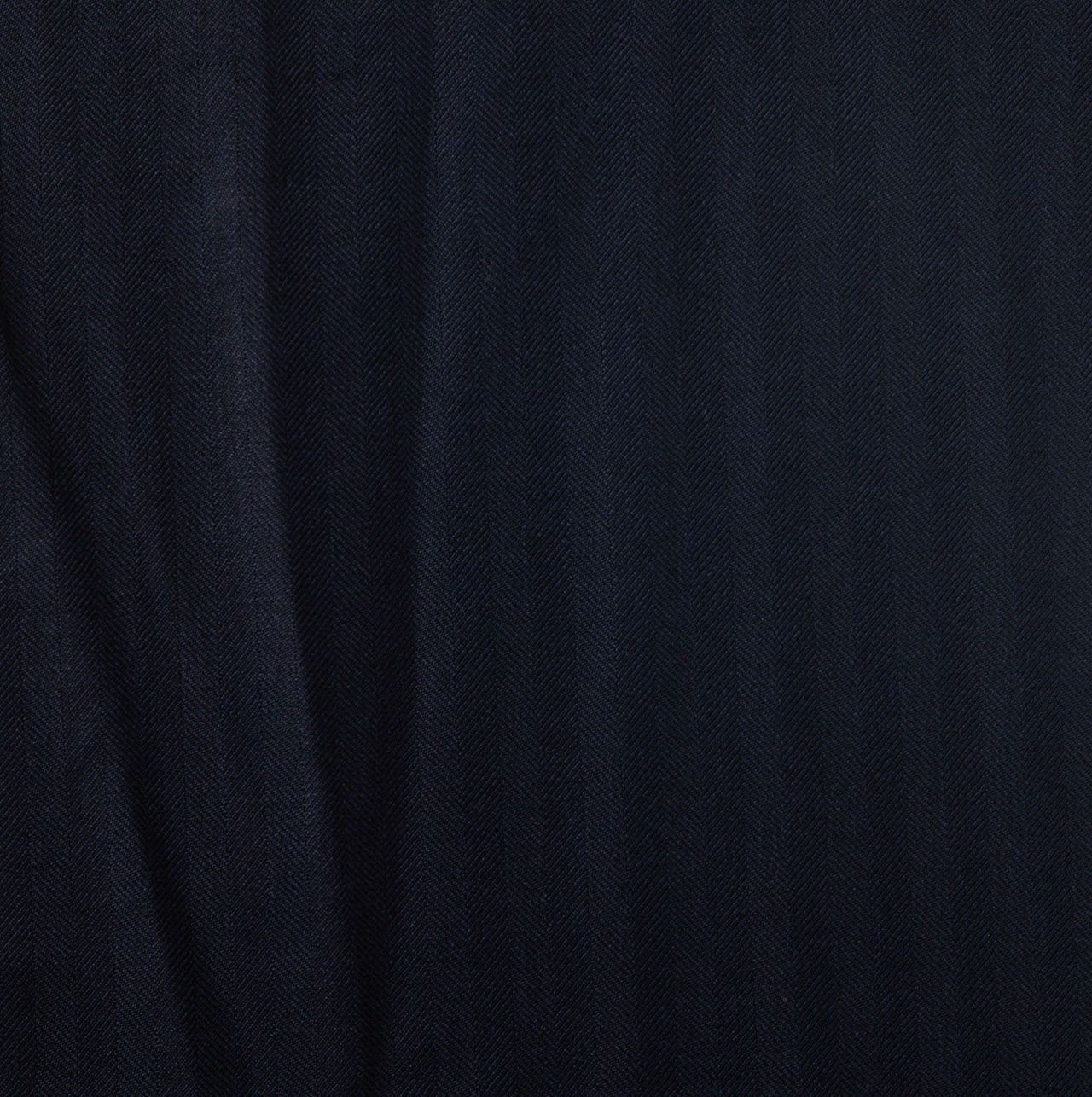 A close up of a dark navy herringbone fabric texture
