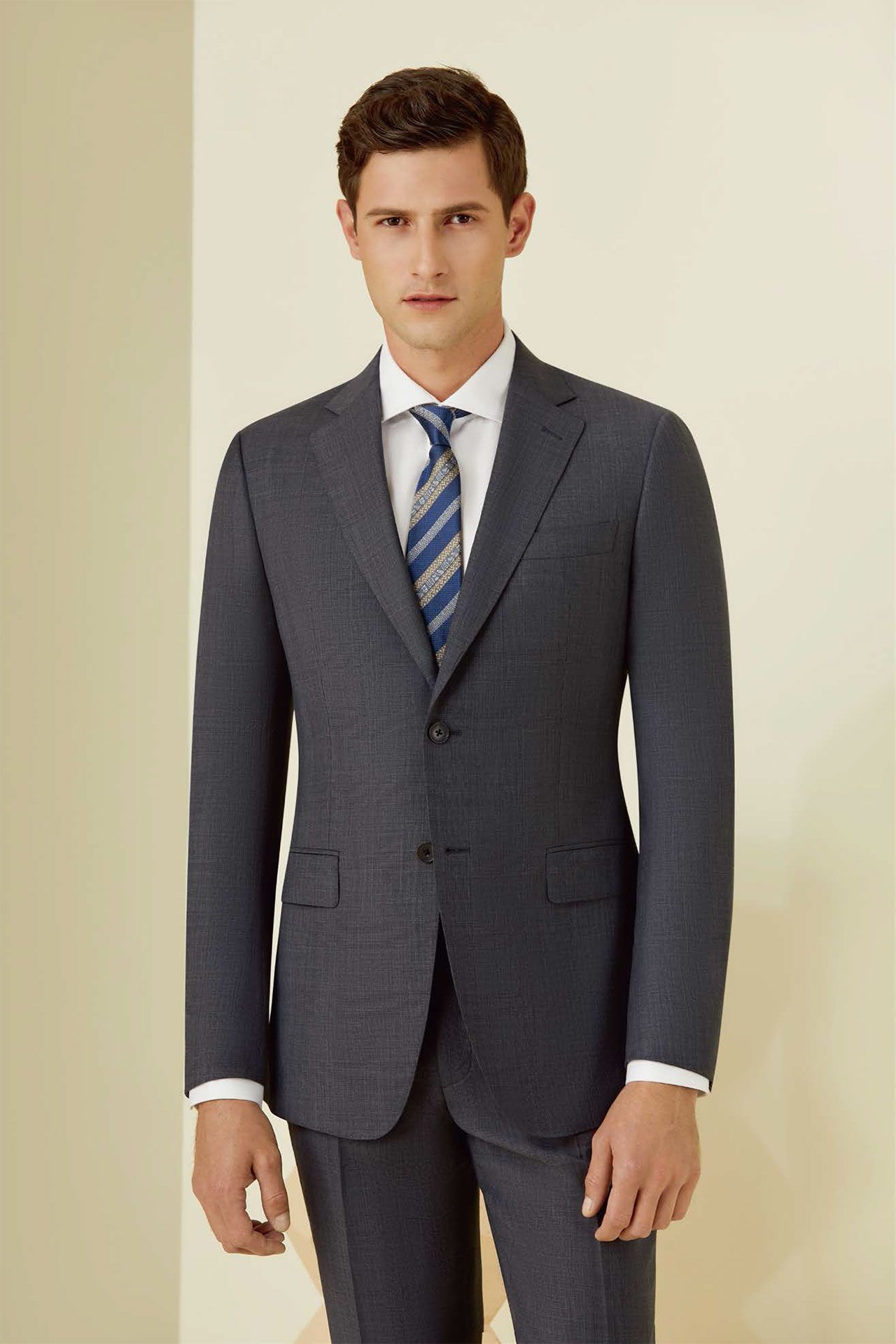 A man in a suit and tie is standing in a room