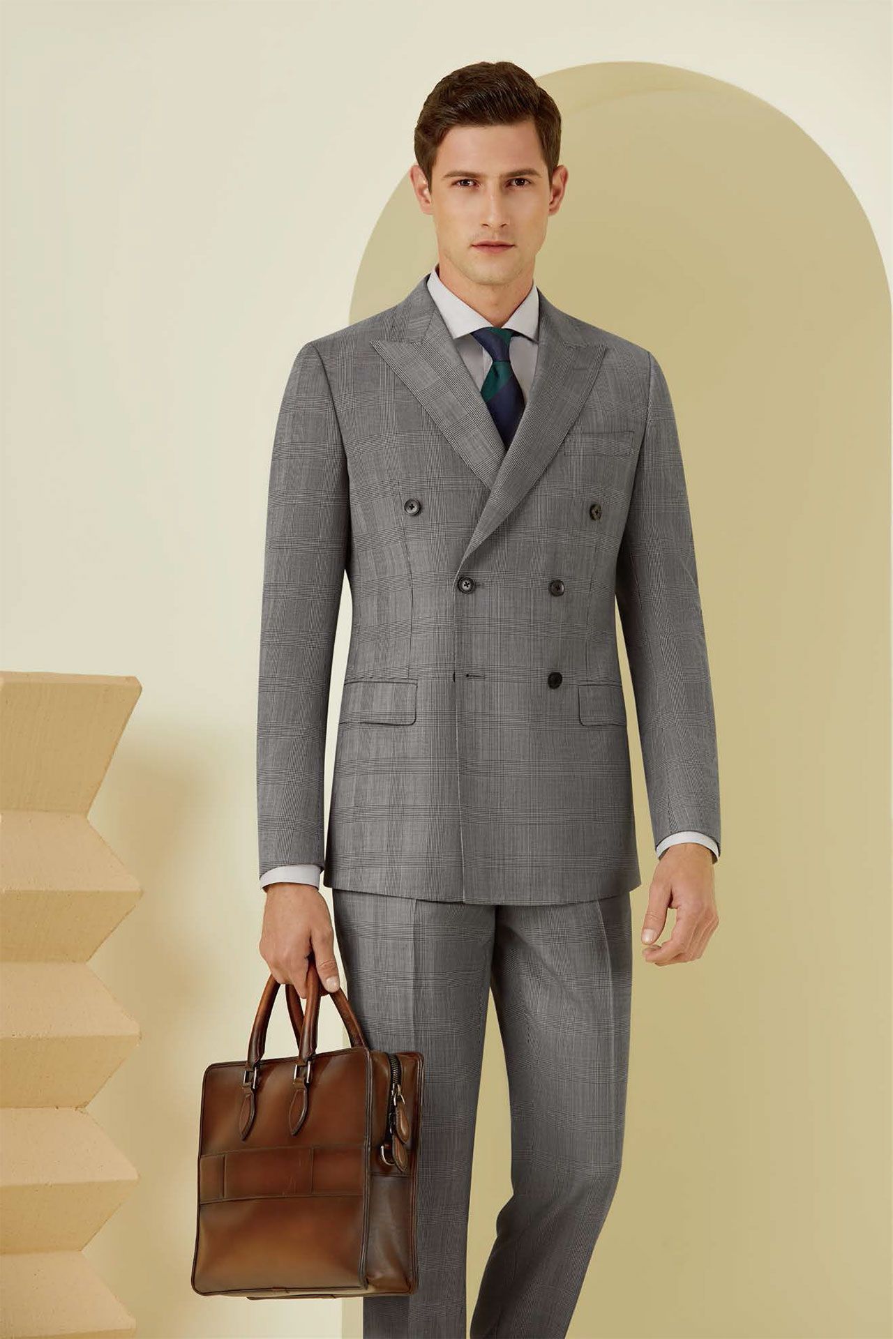 A man in a suit and tie is holding a brown bag