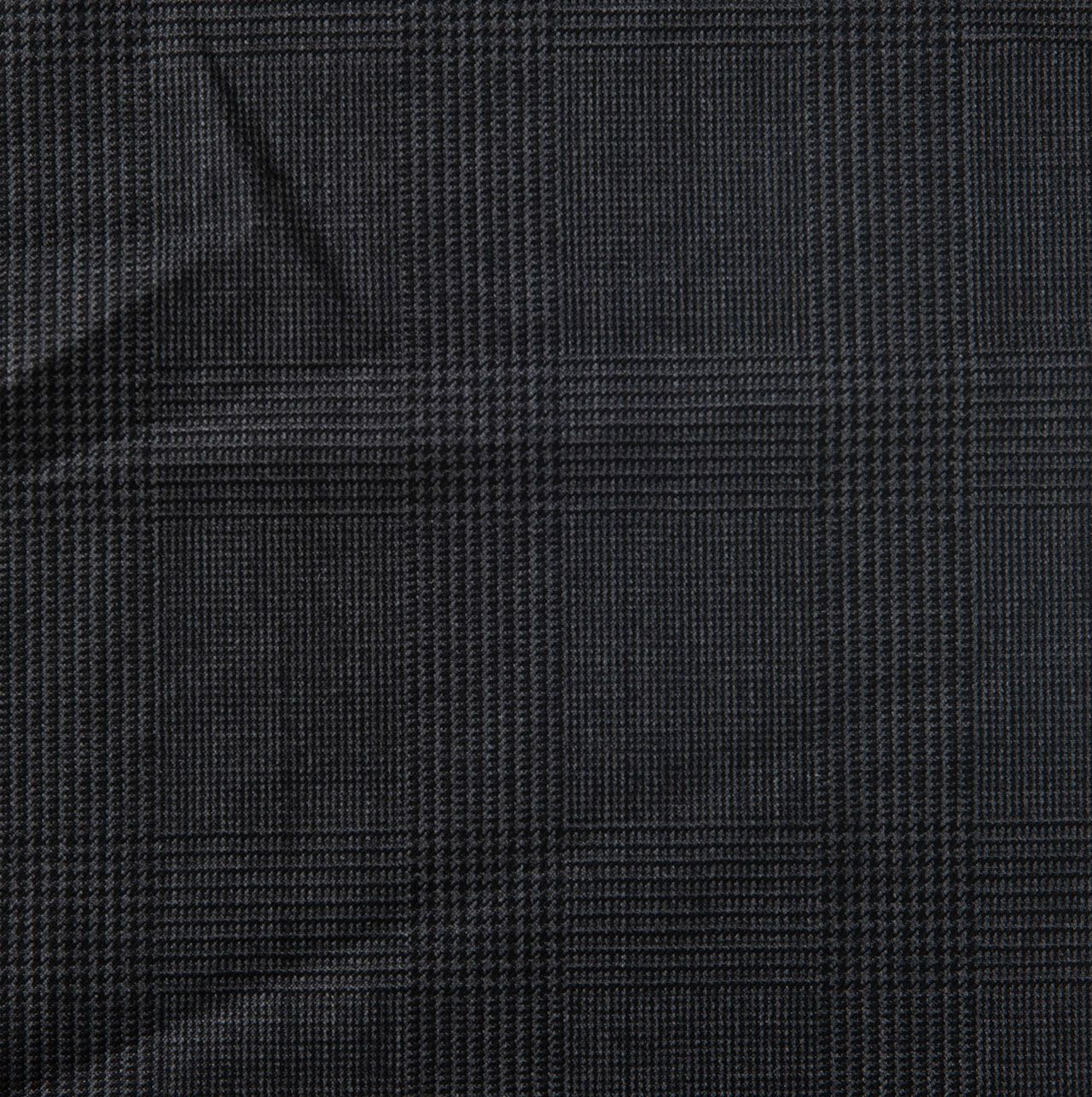 A close up of a piece of dark grey fabric with a checkered pattern