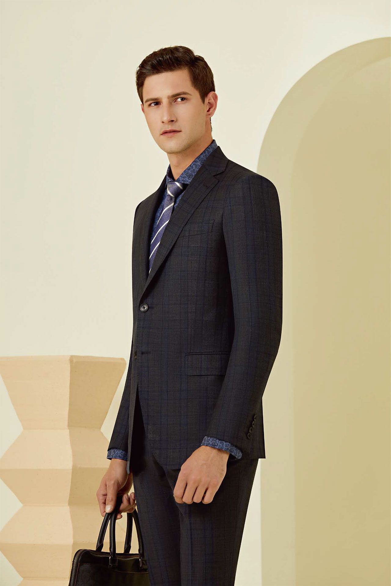 A man in a suit and tie is holding a briefcase