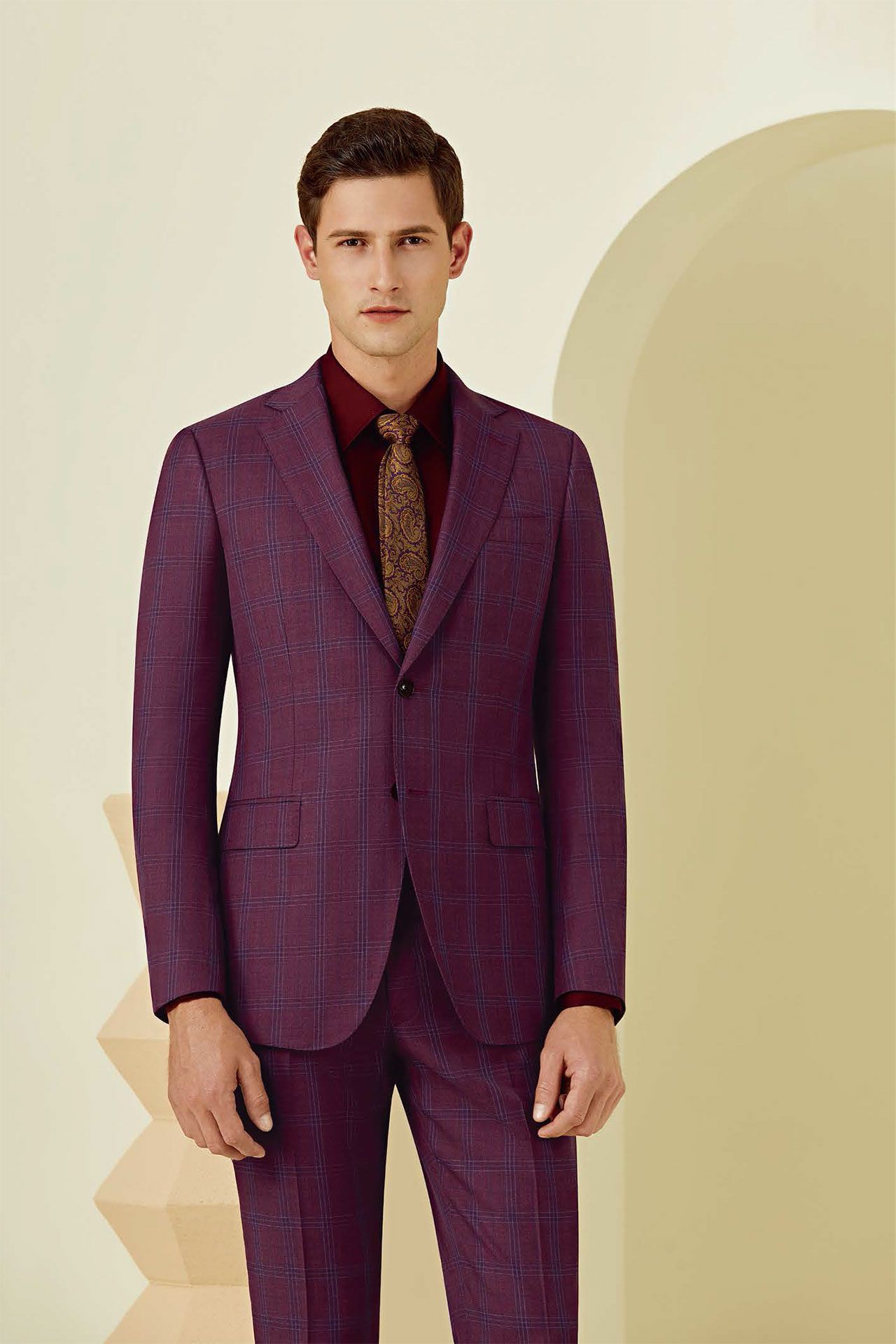 A man is wearing a purple suit and tie