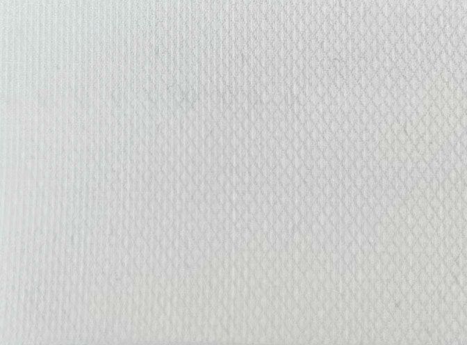 A close up of a white fabric with a diamond pattern