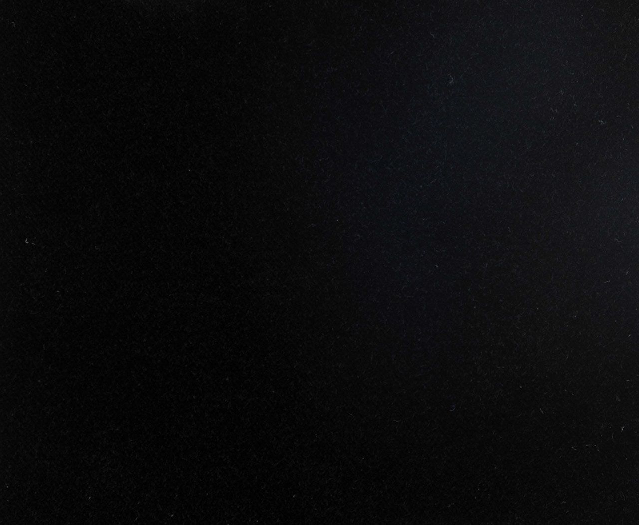 A close up of a black background with a grainy texture