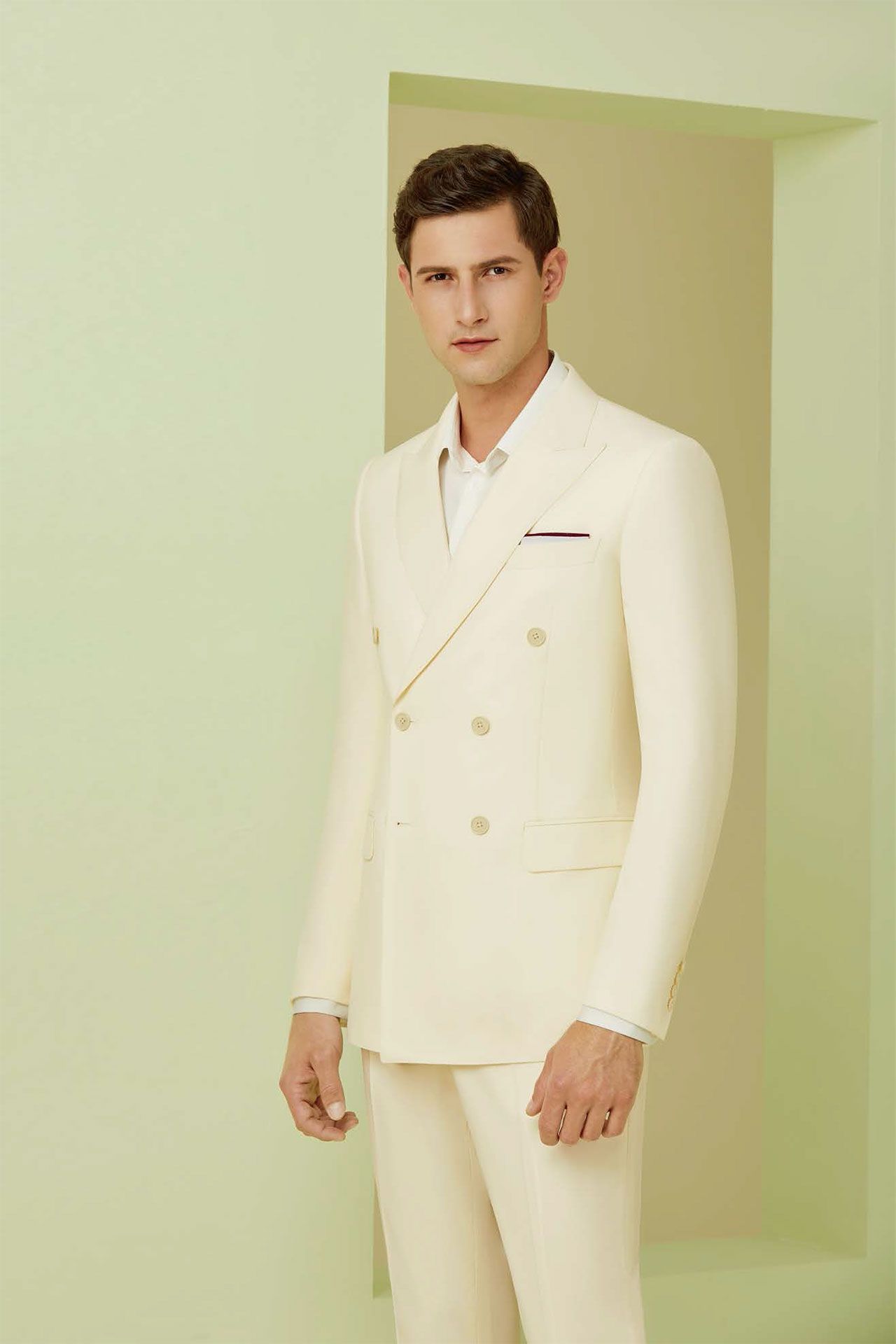 A man in a white suit is standing in a doorway