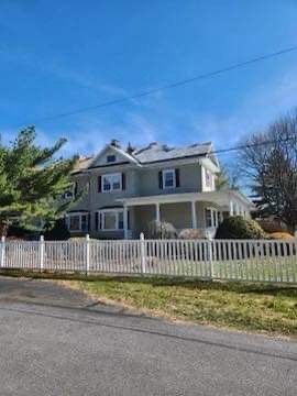 A large house with a white fence in front of it.
