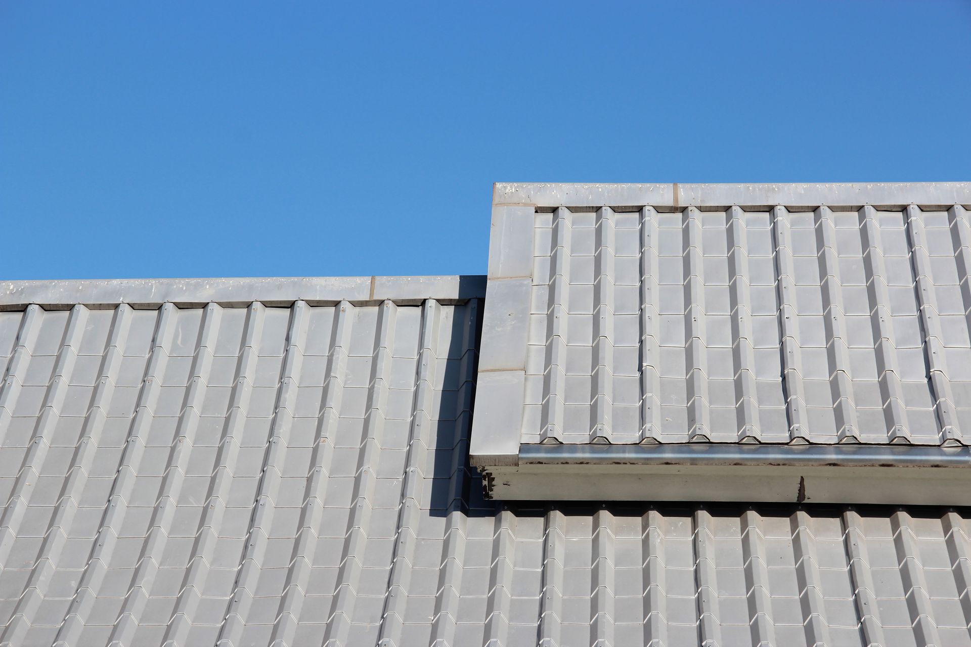 A close up of a roof with a blue sky in the background.
