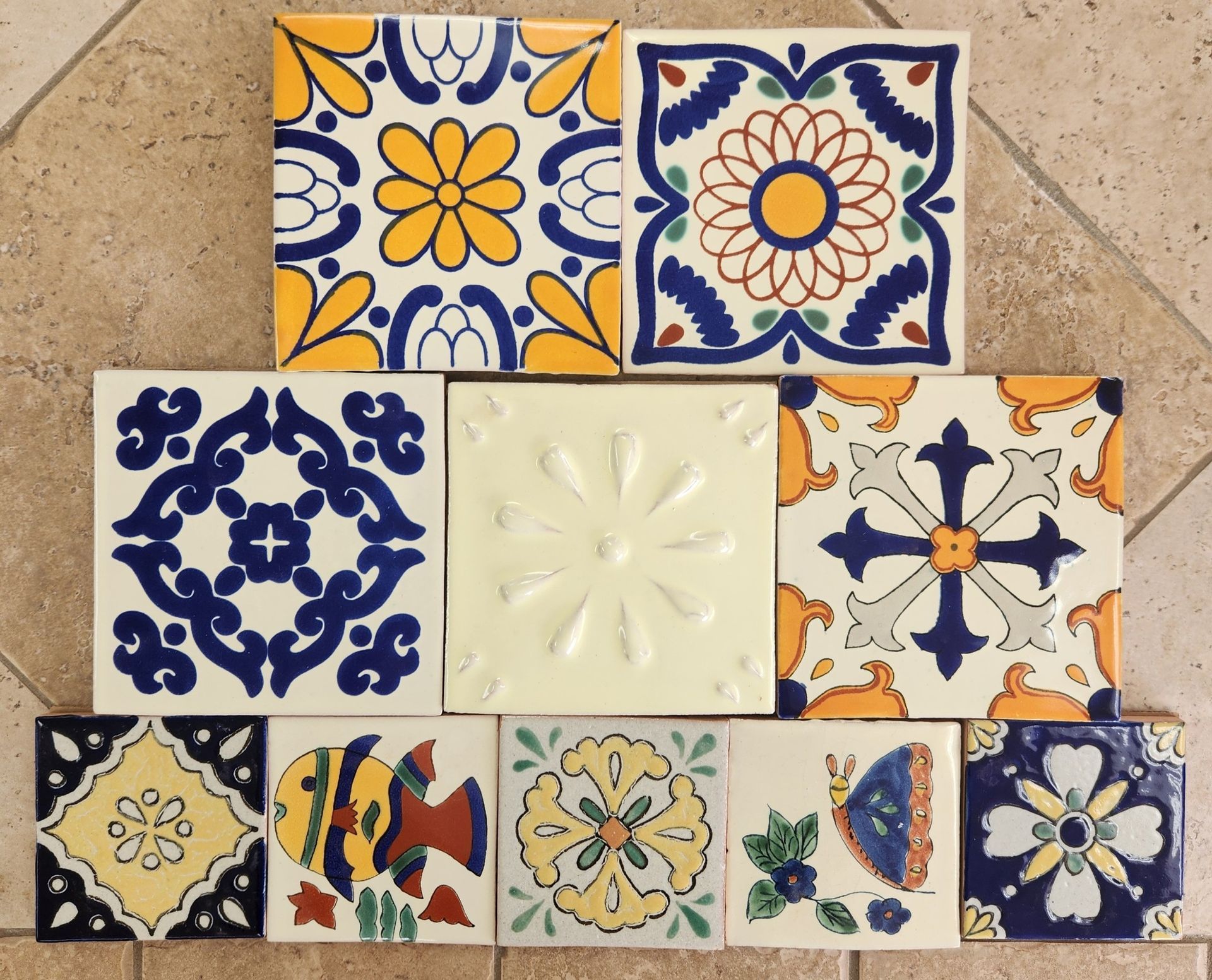 Collection of vibrantly painted ceramic tiles with various floral and geometric patterns.