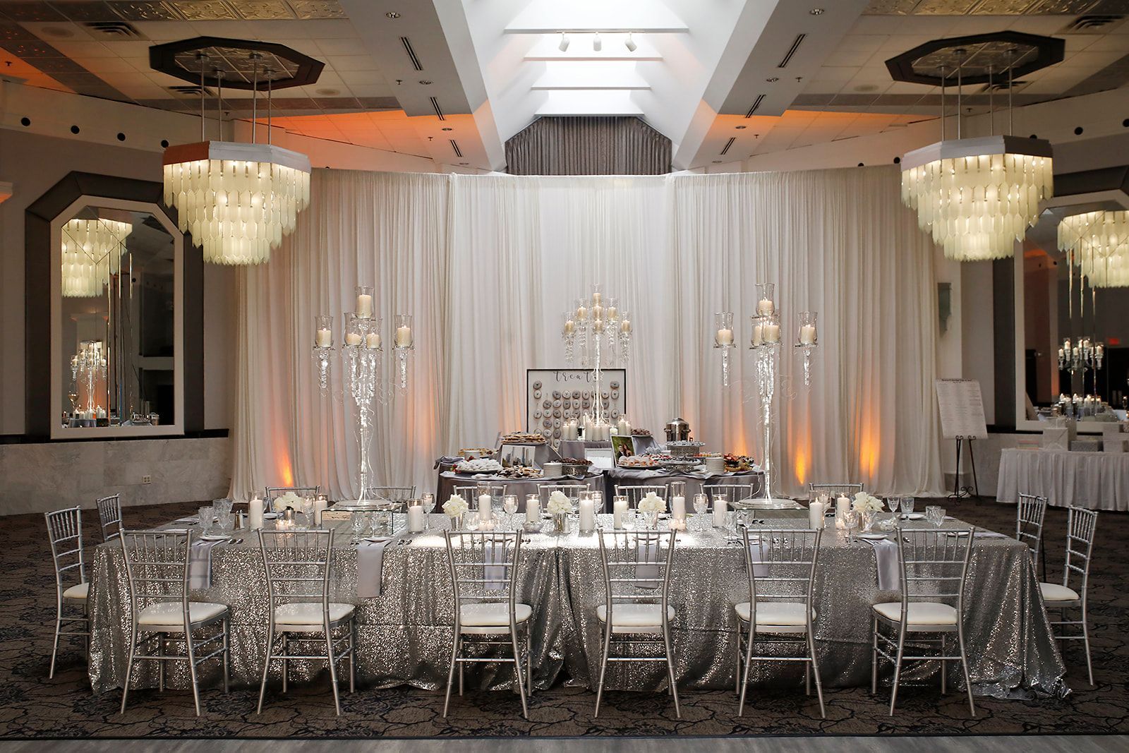 A large room with tables and chairs set up for a wedding reception