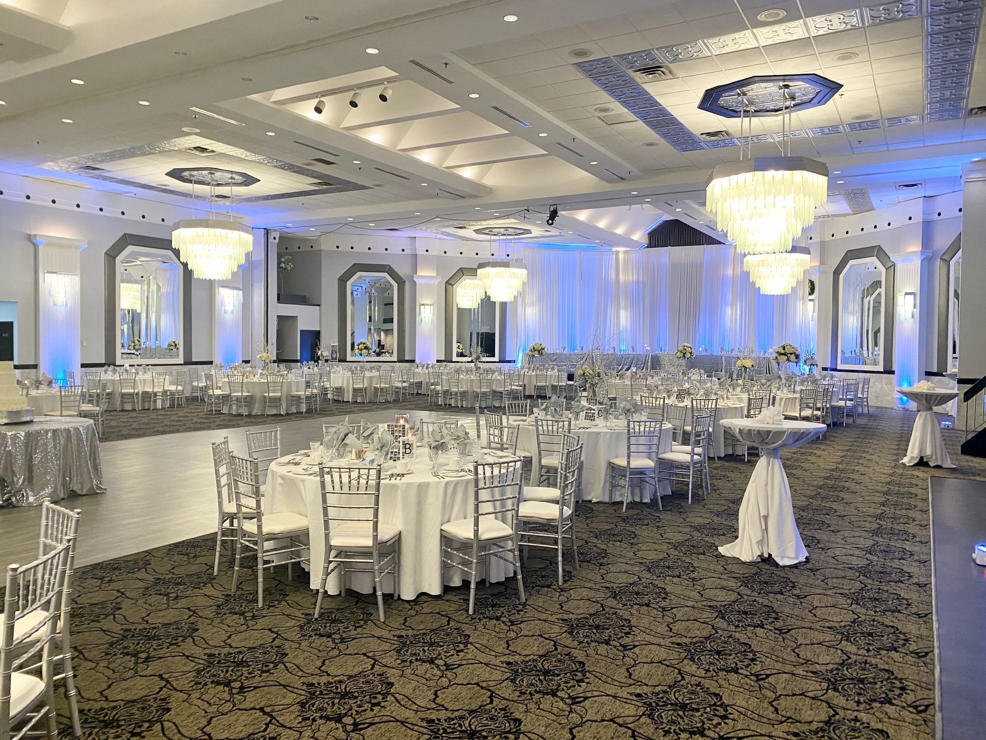A large ballroom with tables and chairs set up for a wedding reception.