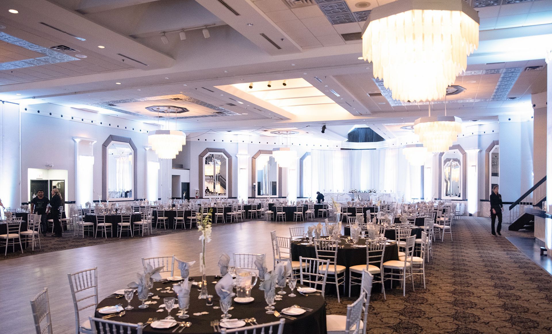 A large ballroom with tables and chairs set up for a wedding reception.