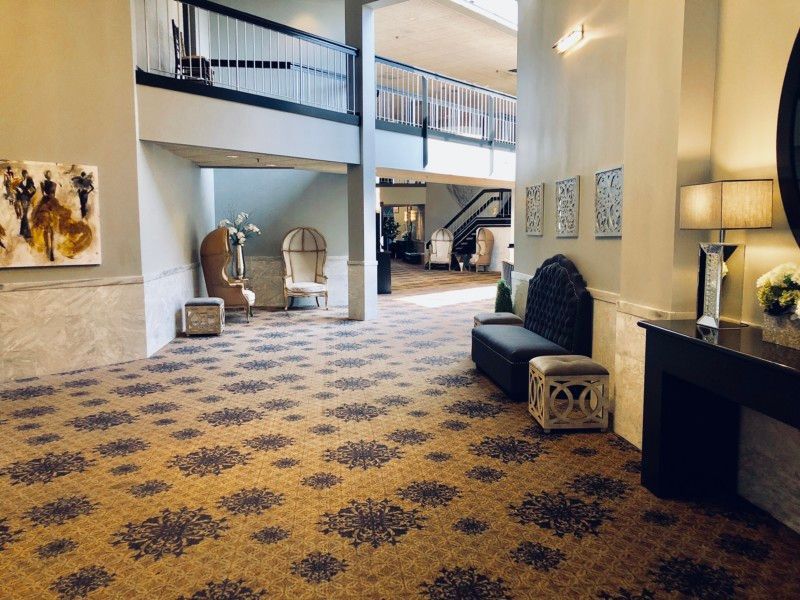 A hotel lobby with a carpeted floor and chairs