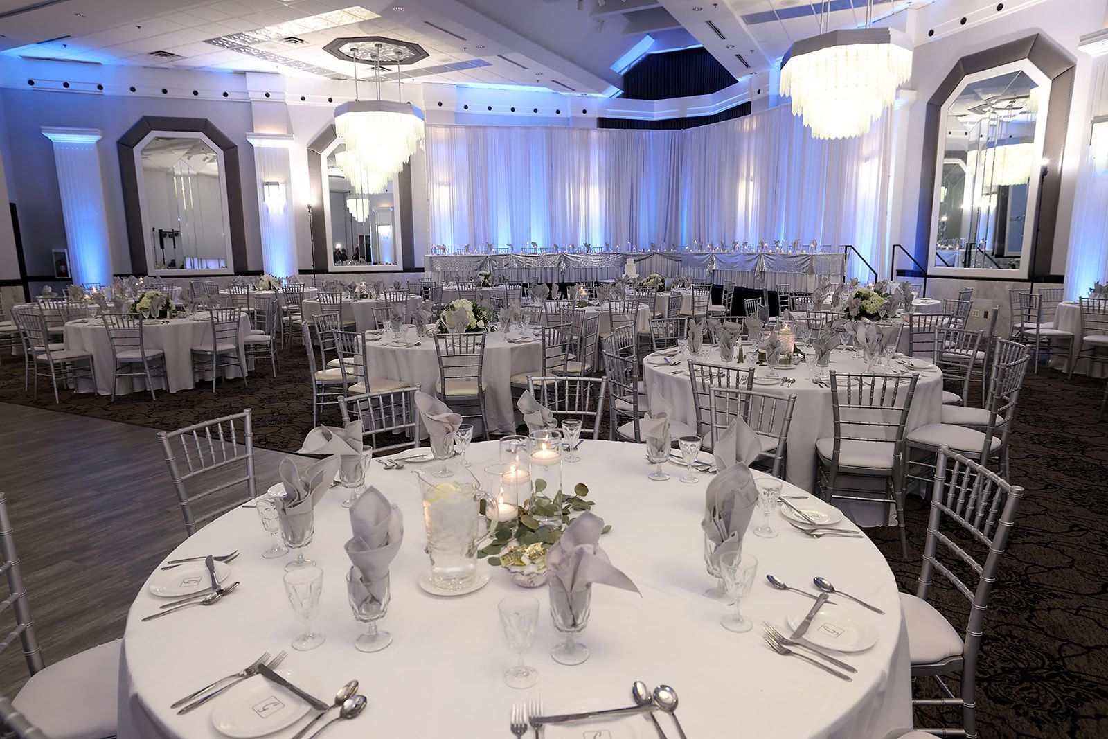 A large room with tables and chairs set up for a wedding reception.