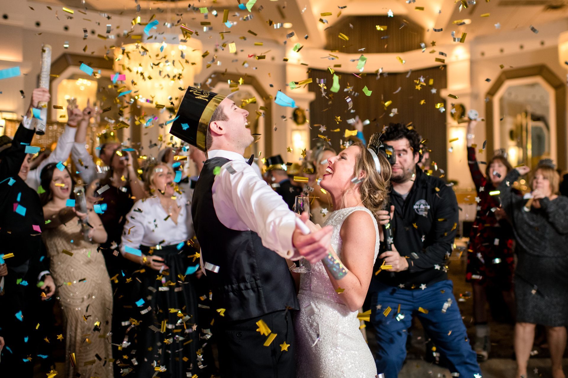 A bride and groom are dancing in front of a crowd of people at a wedding reception.