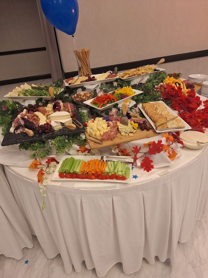 Buffet table with various food platters and a blue balloon.