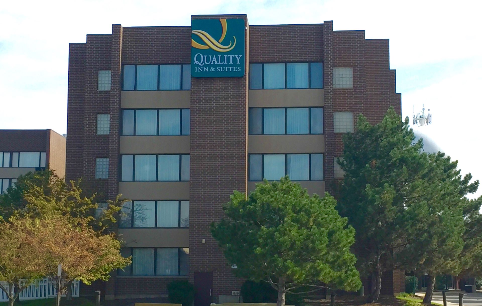 Quality Inn hotel exterior, brick building with green logo sign.