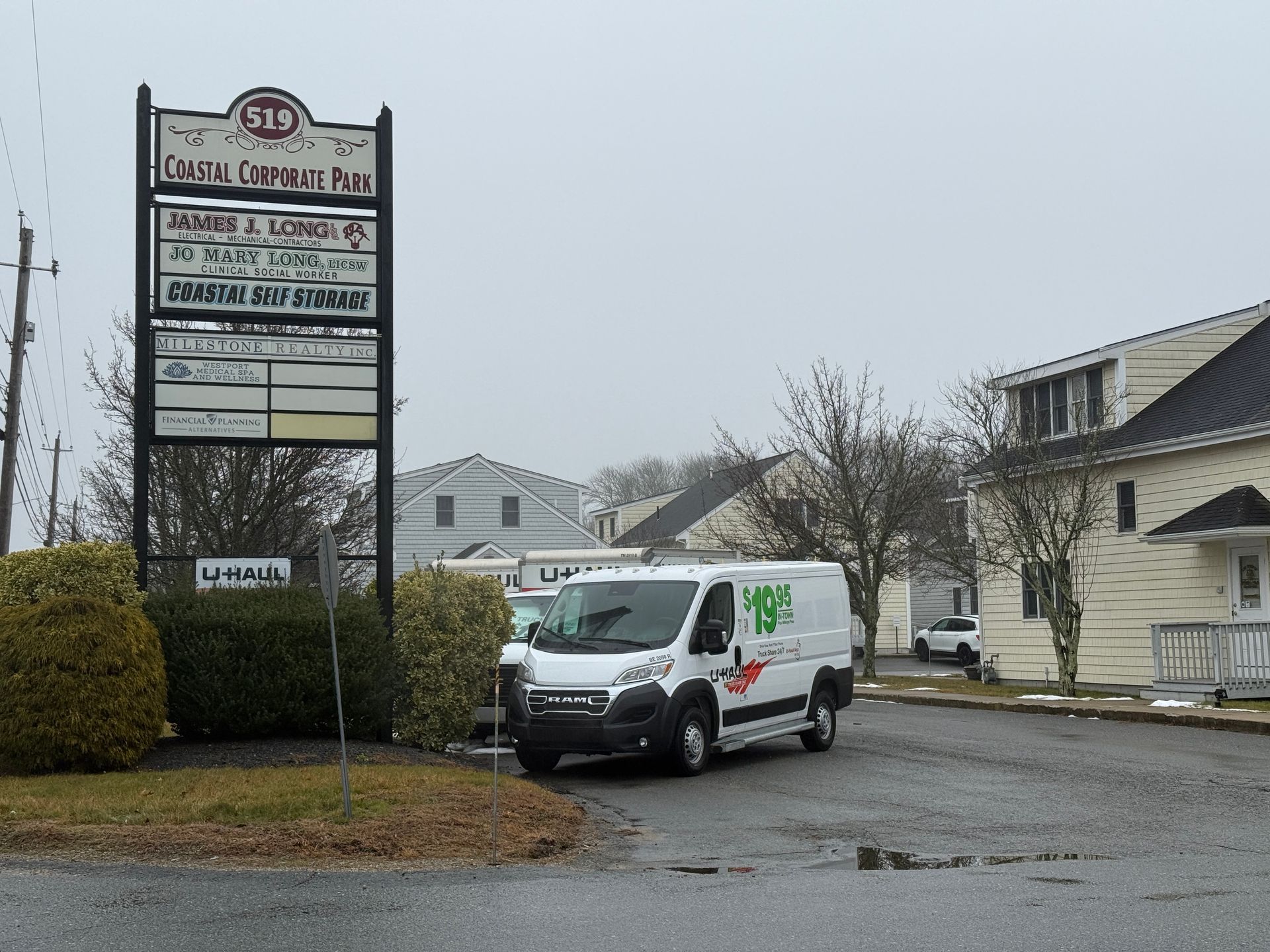 Van parked near a Coastal Corporate Plaza sign. Cloudy day.