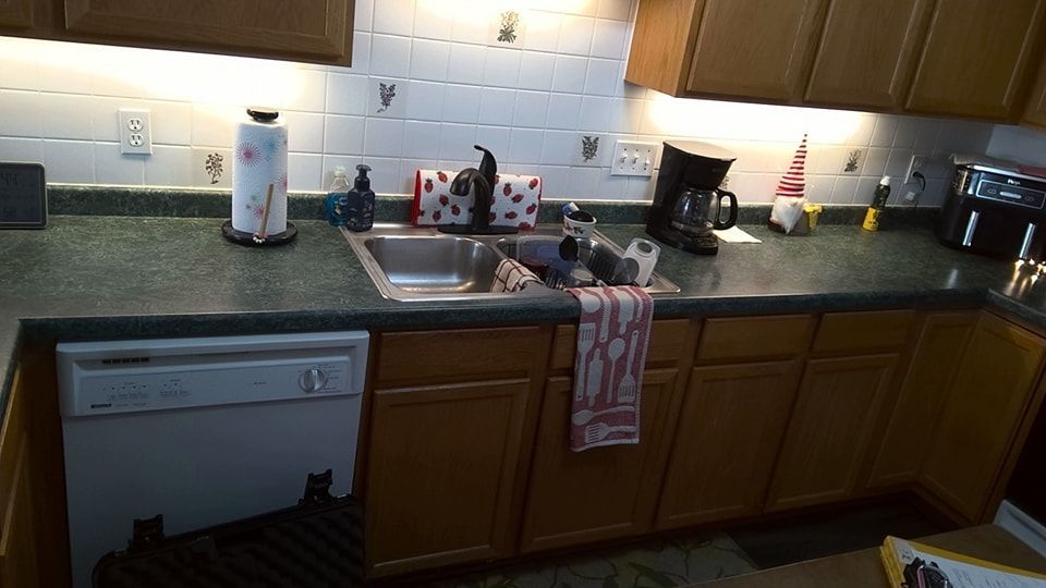 Kitchen counter with sink, cabinets, dishwasher, and appliances. - before