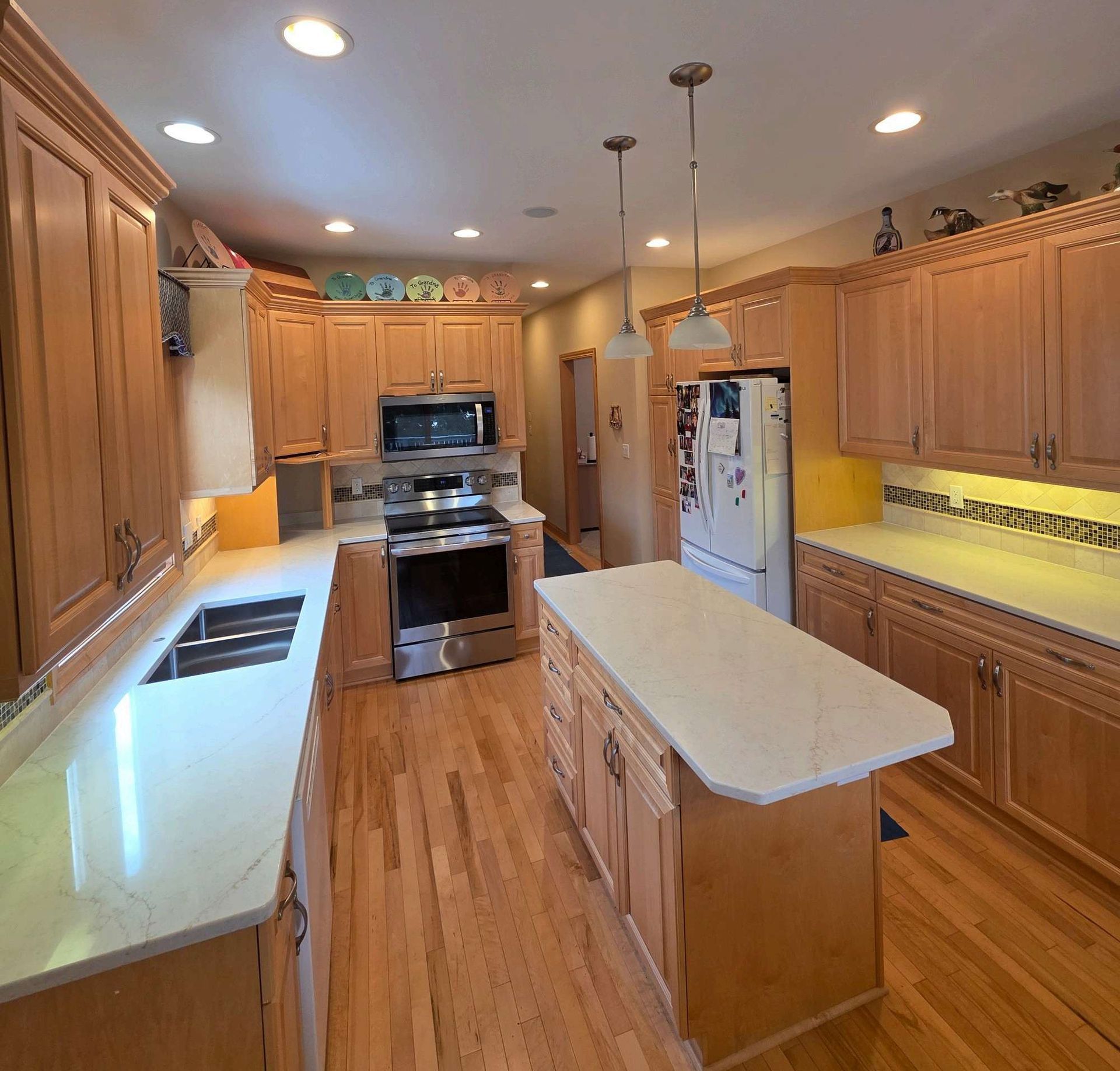Bright kitchen with wooden cabinets, center island, stainless steel appliances, and recessed lighting
