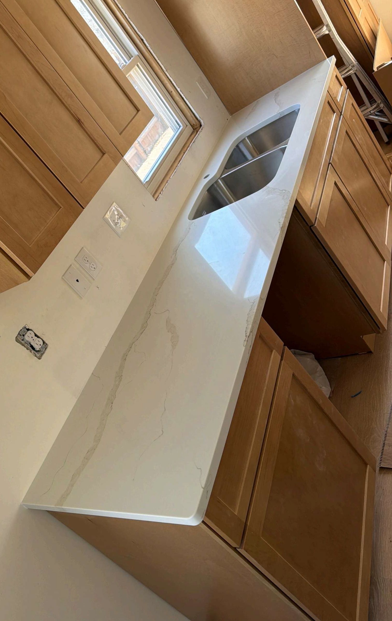 Kitchen interior with white range hood beneath a skylight and wooden cabinets around it