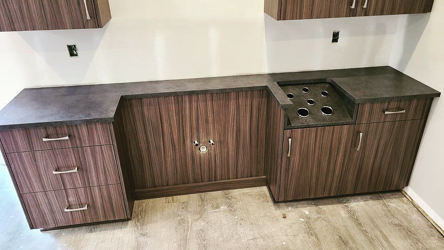 Dark brown wooden cabinets with a dark countertop and a circular cutout for appliances.