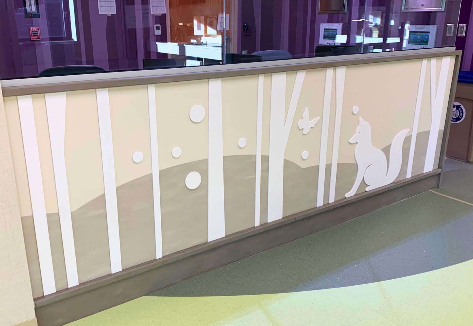 Wooden counter with painted forest scene: trees, fox, circles, and butterfly in muted tones.