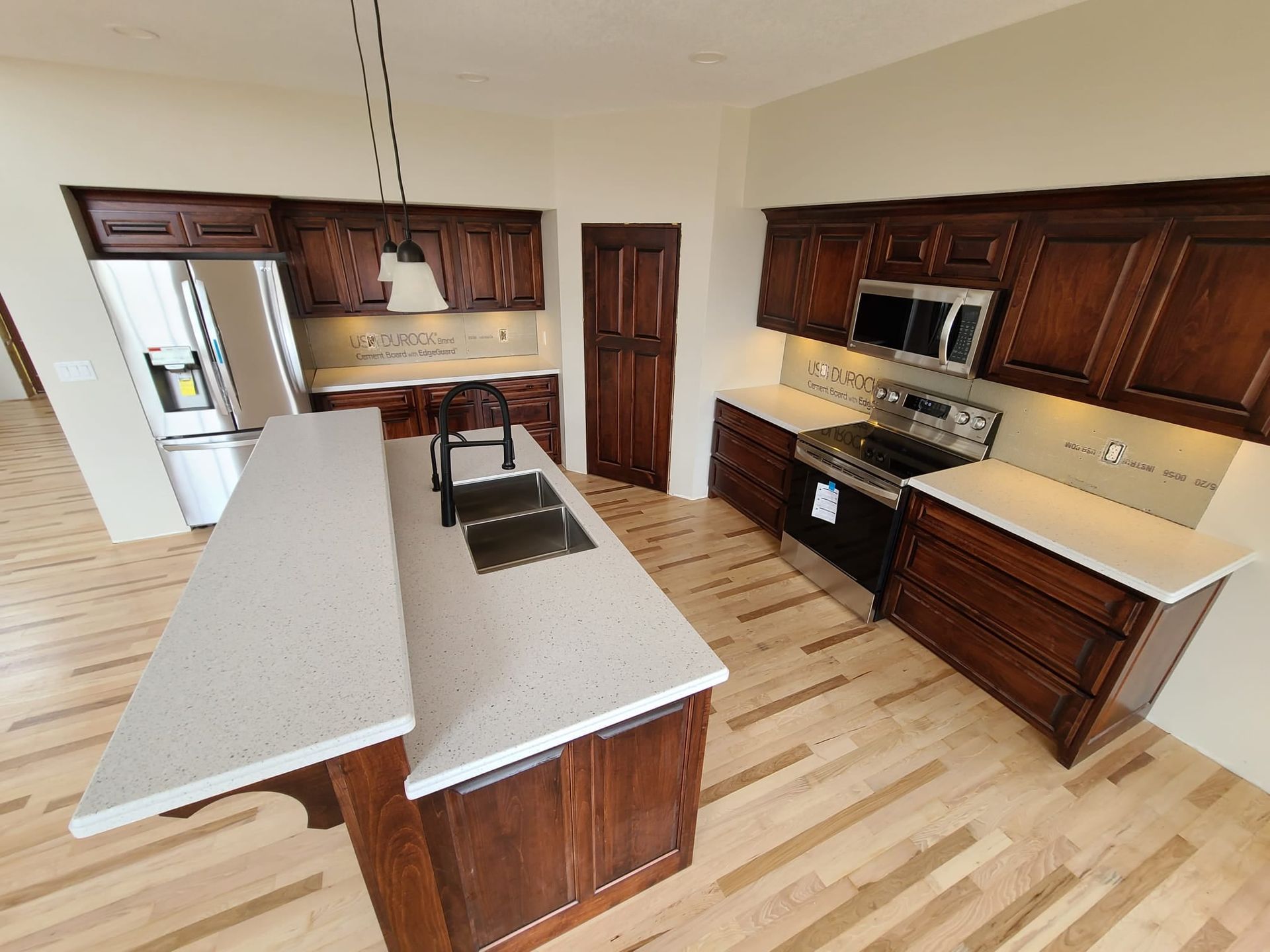 Kitchen with dark brown cabinets, light countertops, and wood floors.