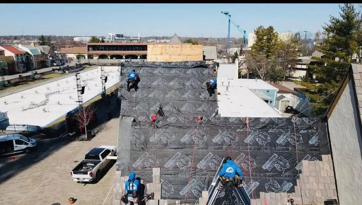 Aerial view of a rooftop with workers and construction materials in a cluttered industrial area